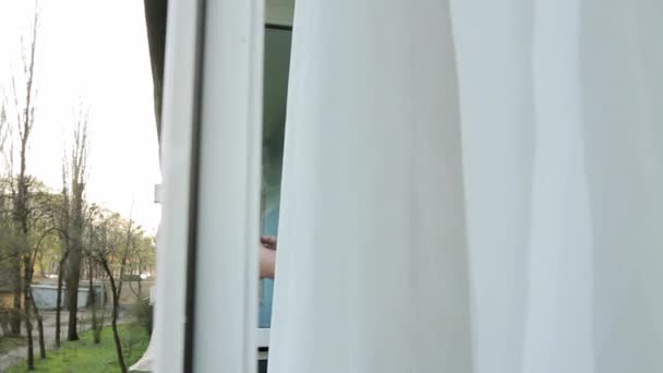 一个戴着医疗面罩的男人打开窗户 从杯子里用稻草有趣地喝水 并从下面提起面罩 照相机通过窗框从左向右运动 — 图库视频影像