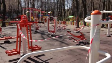 İnsanların olmadığı bir açık hava spor alanı, sinyal bantlarıyla kapalı, rüzgarda sallanan sinyal bantları. Karantina, COVID 19
