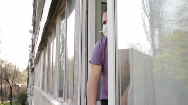 Ein Mann Mit Medizinischer Maske Erscheint Einem Offenen Fenster Hält — Stockvideo