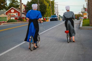 İki çıplak ayak Amish kadın bisiklet üzerinde