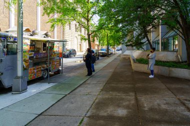 Harrisburg, PA / USA - 15 Mayıs 2020: Şehrin şehir merkezinde yiyecek beklerken bir sokak satıcısının müşterileri sosyal olarak uzaklaşıyor.