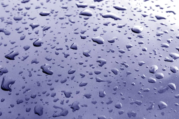 Rain drops on blue metal surface with blur effect — Stock Photo, Image