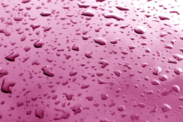 Pembe metal yüzeyi bulanıklık etkisi ile yağmur damlaları