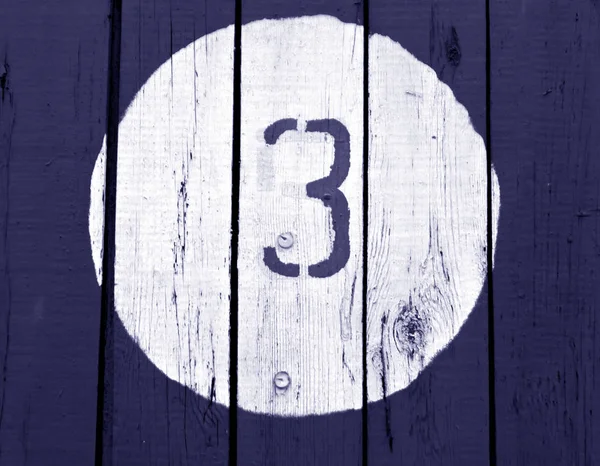 Nummer drie op houten blauw getinte muur. — Stockfoto