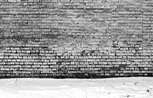 Стена из выветренного кирпича и куча снега . — стоковое фото