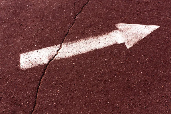 Flecha branca na superfície de asfalto marrom . — Fotografia de Stock