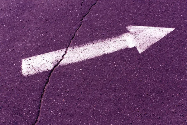 Flecha branca na superfície de asfalto roxo . — Fotografia de Stock