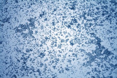 Mavi tonda pencere yüzeyinde kar.