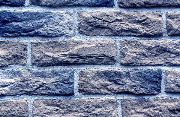 Blue toned brick wall surface.