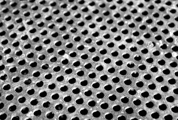 Weathered gray metal surface with holes and blur effect — Stock Photo, Image