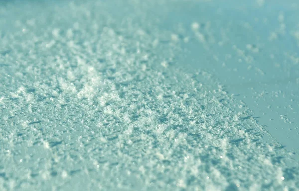 Сніг на блакитній тонованій металевій поверхні автомобіля з ефектом розмивання . — стокове фото