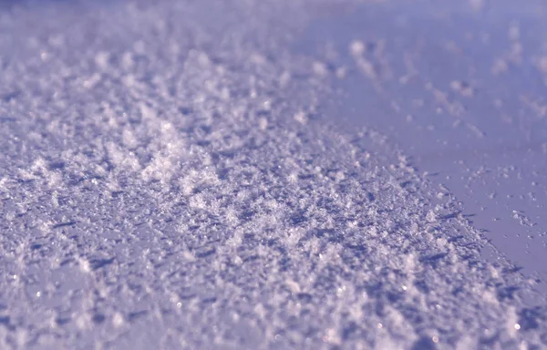 Neve na superfície do carro de metal azul com efeito de borrão . — Fotografia de Stock