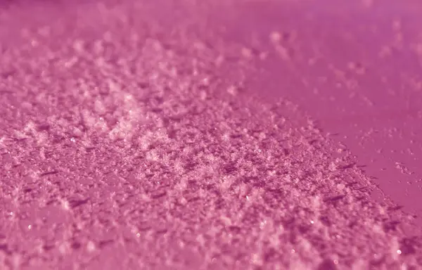 Snow on pink metal car surface with blur effect. — Stock Photo, Image