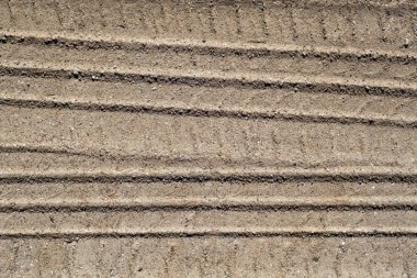 Kumlu yolda araba parçaları.