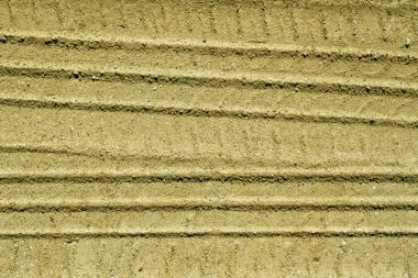 Kumlu yolda araba parçaları.