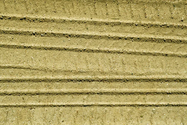 Kumlu yolda araba parçaları.