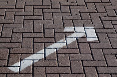 Kaldırım üzerindeki oku beyaz boyalı.