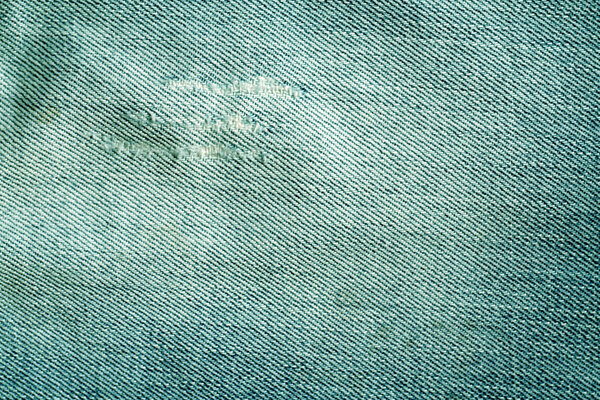 Old cyan color jeans texture with scratches. 