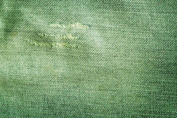 Old green jeans texture with scratches.