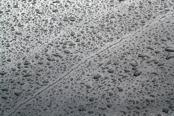 Gocce di pioggia sulla superficie dell'auto in metallo di colore grigio . — Foto Stock