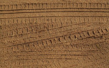 Kumlu yolda araba parçaları.