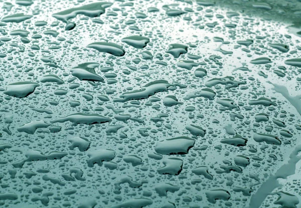 シアン色ぼかし効果を持つ金属表面上の水滴 — ストック写真