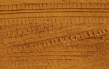 Kumlu yolda araba parçaları.