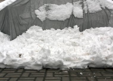 Gri çadır ve kar yığını.