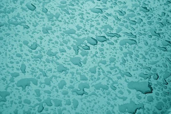 Vatten droppar på metallytan i cyan färg. — Stockfoto