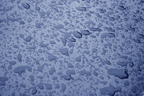 Gotas de água na superfície do metal na cor azul . — Fotografia de Stock