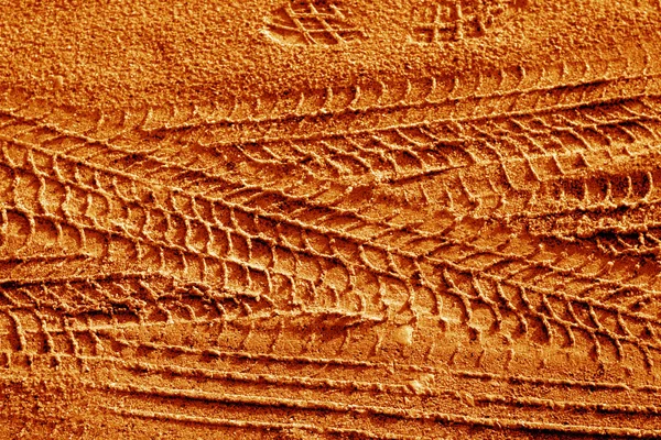 Κομμάτια ελαστικού στην άμμο σε πορτοκαλί τόνος. — Φωτογραφία Αρχείου