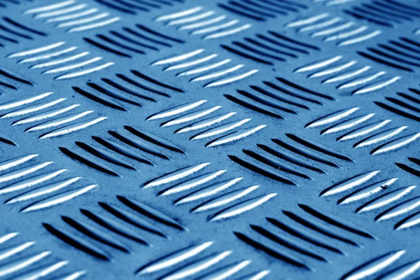 Diamond shaped metal floor pattern with blur effect in navy blue