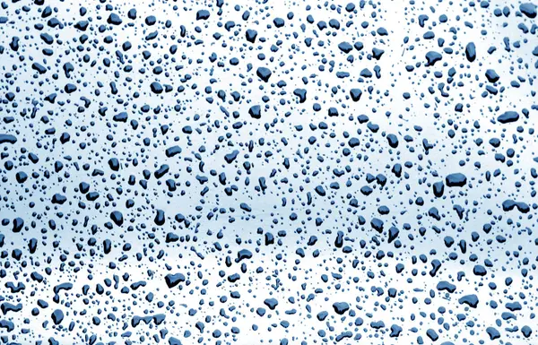 Regnet droppar på bilfönstret i marinblå ton. — Stockfoto