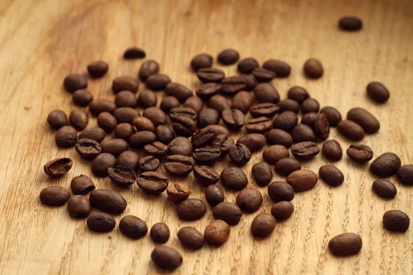 Granos de café sobre tabla de madera con efecto difuminado . —  Fotos de Stock