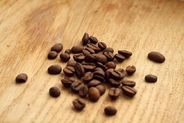 Granos de café sobre tabla de madera con efecto difuminado . —  Fotos de Stock