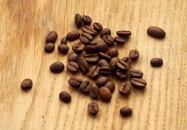 Grãos de café na placa de madeira com efeito borrão . — Fotografia de Stock