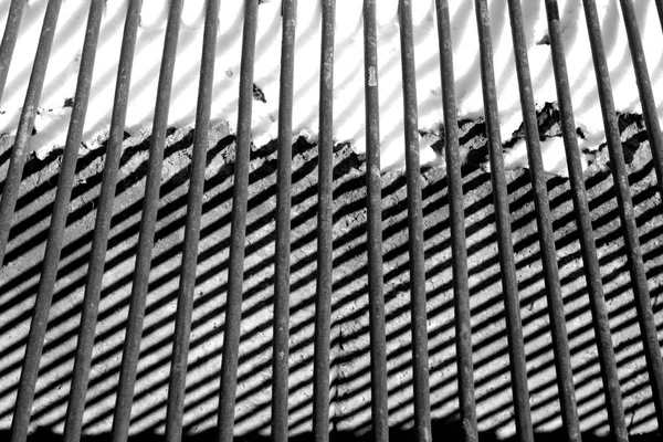 Metal grid, its shadow and snow in black and white. — Stock Photo, Image