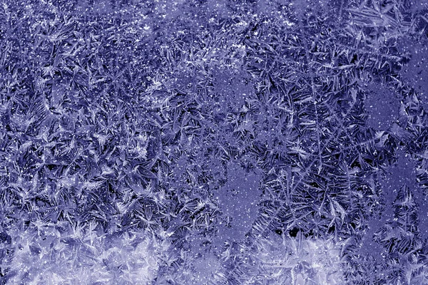 Bela geada e padrão de gelo na superfície da janela em tom azul . — Fotografia de Stock