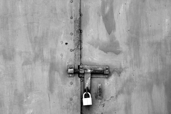 Vieux cadenas sur porte métallique en noir et blanc . — Photo