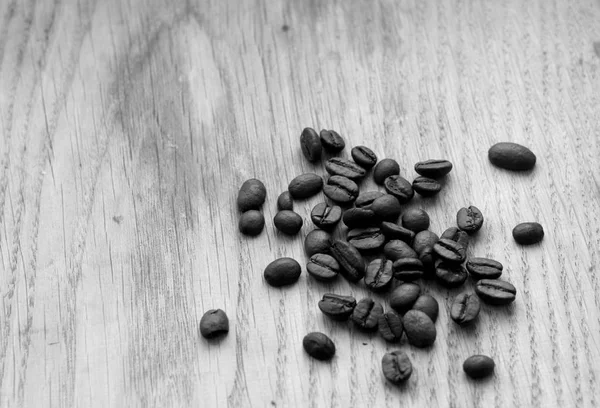 Grãos de café na placa de madeira com efeito borrão em preto e branco — Fotografia de Stock