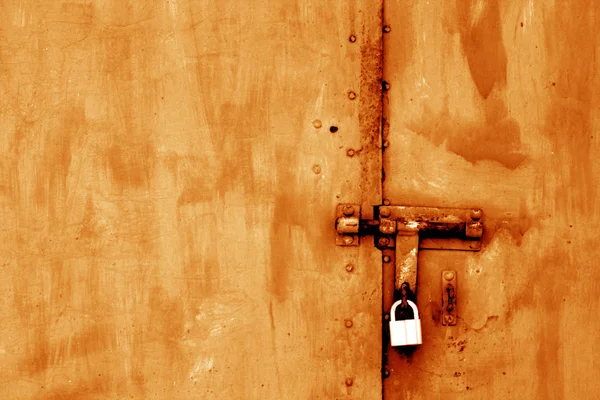 Old padlock on metal gate in orange tone. — Stock Photo, Image