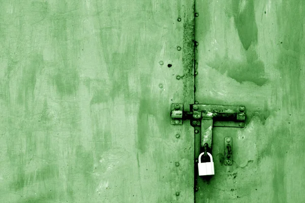 Vieux cadenas sur porte métallique en ton vert . — Photo