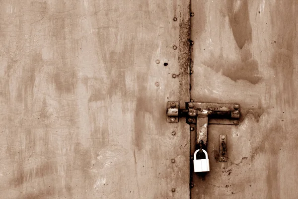 Antiguo candado en puerta de metal en tono marrón . — Foto de Stock