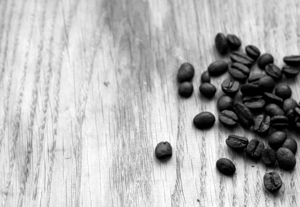 Grãos de café na placa de madeira com efeito borrão em preto e branco — Fotografia de Stock