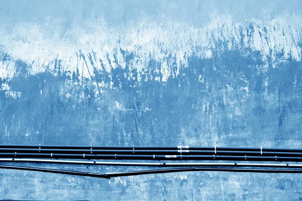 Кабелі на старій гранжевій цементній стіні в темно-синьому тоні . — стокове фото