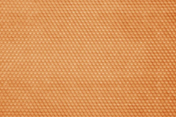 Honeycomb wax texture in orange tone.