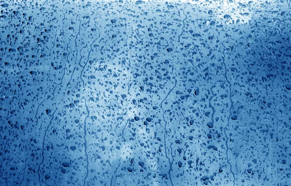 Вода на размытом окне в темно-синем тоне . — стоковое фото