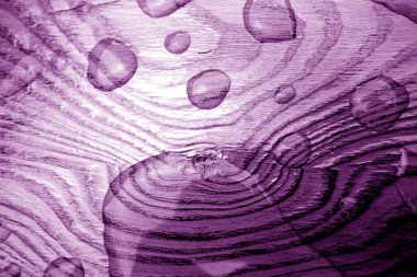 Water drop on wooden surface in purple tone. clipart