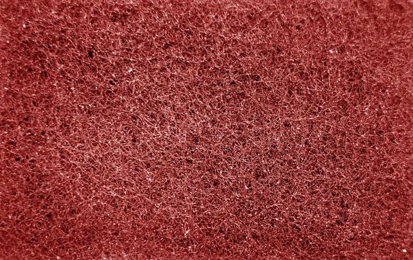 Limpiar la superficie de frotamiento de esponja de cerca con efecto difuminado en rojo —  Fotos de Stock