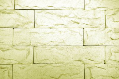 Sarı tonda dekoratif tuğla duvar.
